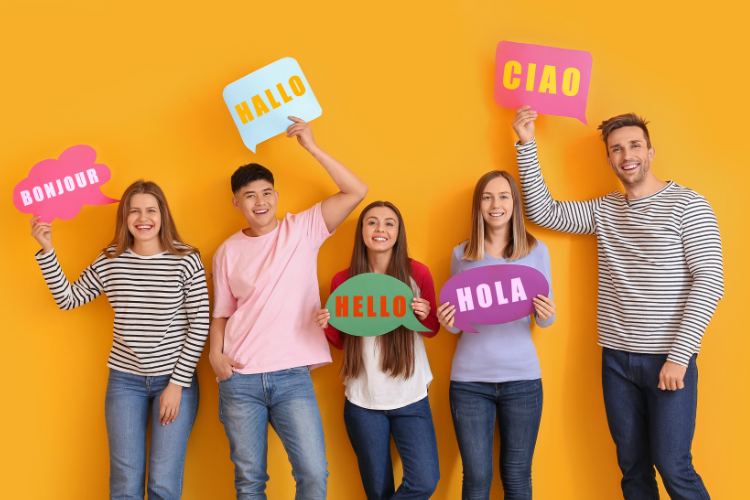 Junge Menschen aus dem Ausland für Ausbildungsplätze begeistern Junge Menschen aus verschiedenen Laendern stehen nebeneinander. Sie halten jeweils ein Schild hoch auf dem Hallo auf ihrer jeweiligen Sprache steht.